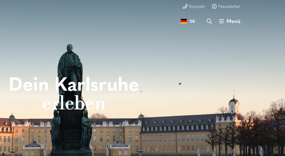 Startseite von karlsruhe-erleben.de: die Überschrift Dein Karlsruhe erleben über dem Karlsruher Schloss in der Dämmerung.